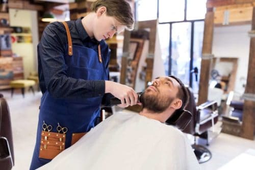 Barber creating a beard fade with a trimmer