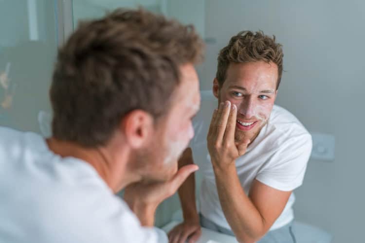 Washing face and beard with soap or an exfoliant before applying beard balm.