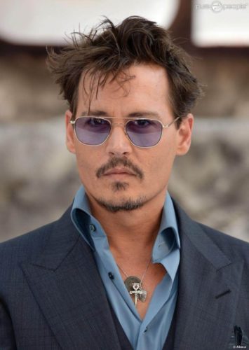 Johnny Depp with short hair and purple tinted aviator glasses.