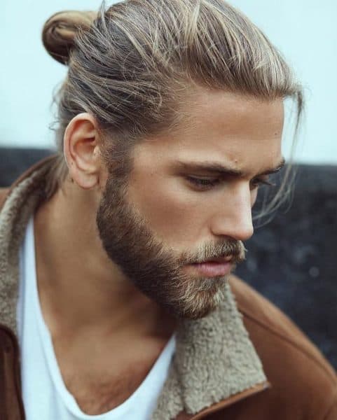 A modern lumberjack beard style with a trendy man bun.